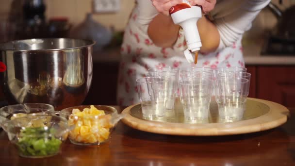 Nahaufnahme der Tassen, wo der Koch einen Karamellsirup aus der Flasche gießt — Stockvideo