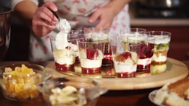 Kockar handen, som sätter krämen i koppar, där det blir desserter — Stockvideo