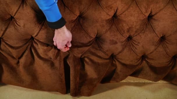 Nahaufnahme eines Mannes, der die weiche Polsterung des Sofas anpasst — Stockvideo