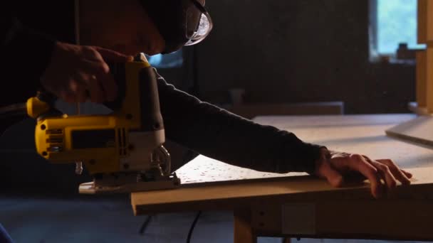 O carpinteiro detém cortadores elétricos para o trabalho em madeira em uma pequena empresa — Vídeo de Stock