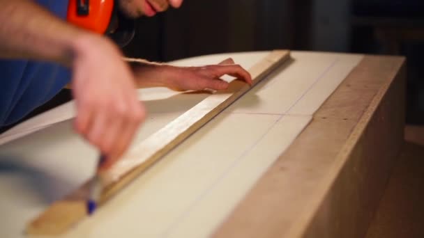Employees hands, who draws a line using a felt-tip pen and ruler on furniture — Stock Video