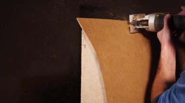 Çalışan elektrikli testere bir kontrplak üzerine kullanır.