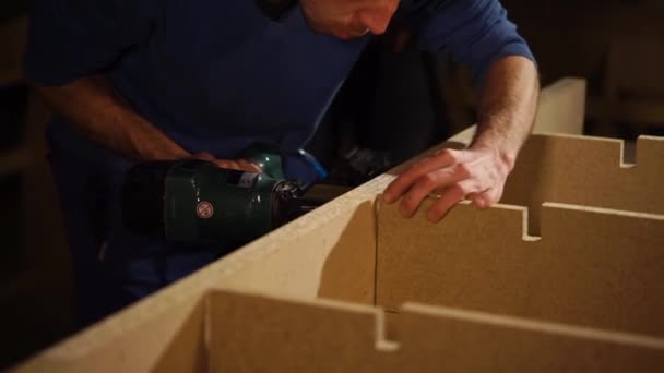 Мужчина собирает мебель на ткани — стоковое видео