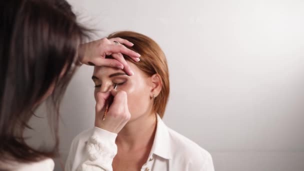 Maquillaje artista preparándose su modelo — Vídeos de Stock