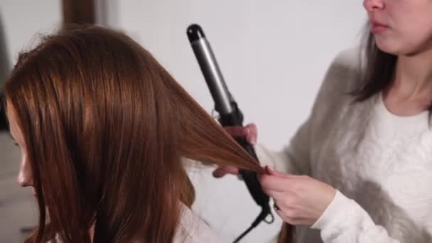 뷰티 살롱에서 컬링 살롱으로 곱슬 머리를 만드는 여자의 초상화 — 비디오