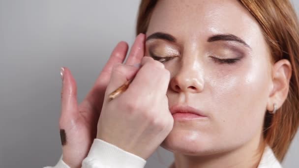 Primer plano de la artista de maquillaje que utiliza delineador de ojos oscuro para enfatizar los ojos — Vídeos de Stock