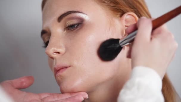 El cliente está sentado queitly durante el maquillaje — Vídeos de Stock
