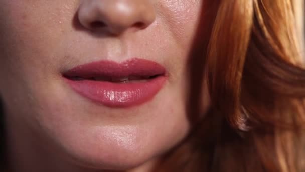 Primer plano de los labios de una mujer que muerde eróticamente la parte inferior del labio — Vídeo de stock