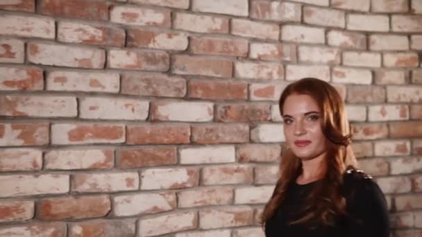 Attractive model walks by the brick wall — Stock Video