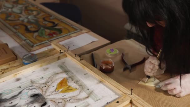 Masters hands, who cuts out the material of the petal for stained glass window — Stock Video