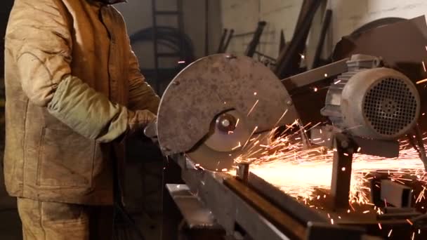 Worker cuts metal rods with grinder — Stock Video