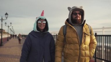 Yetişkin bir adam ve kız arkadaşı cadde boyunca güneşli bir günde yürüyor