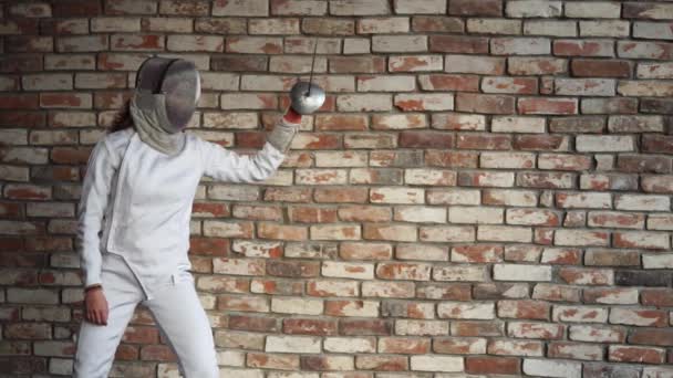 Bir kadın koruyucu bir kask içinde profesyonel çit yeteneğini gösterir — Stok video