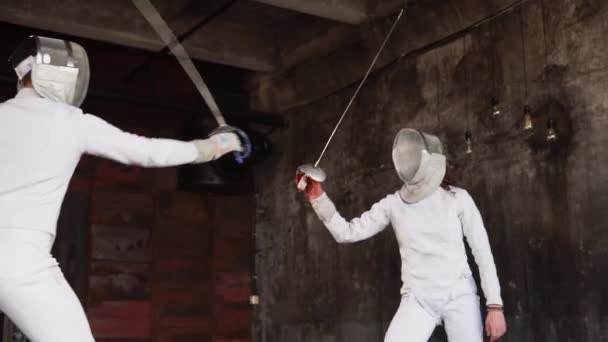 Чоловік і його учень практикують фехтування, вони тримають мечі в руках — стокове відео