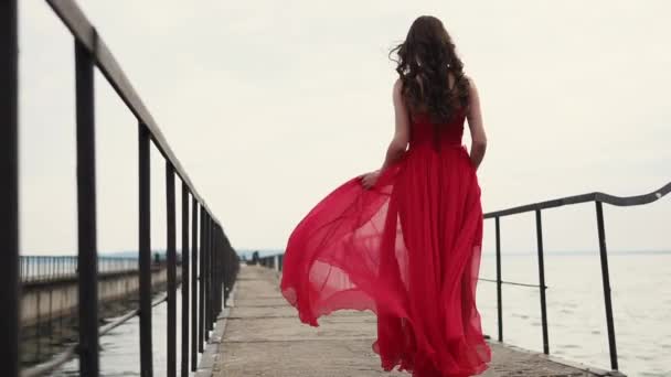 Mujer solitaria romántica está caminando en el viejo muelle vacío de mar en el día, vista trasera — Vídeo de stock