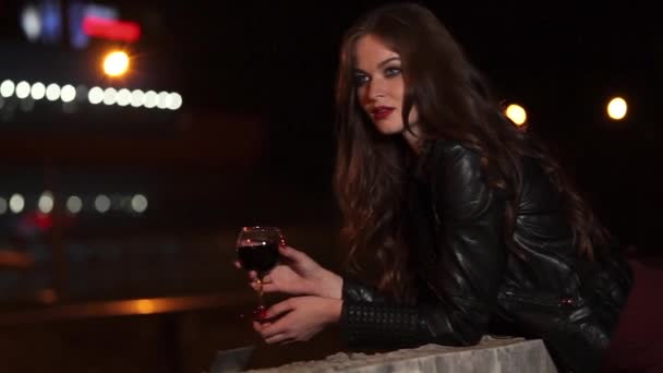 Single romantic lady with red wine glass in a hand on dark night street — Stock Video