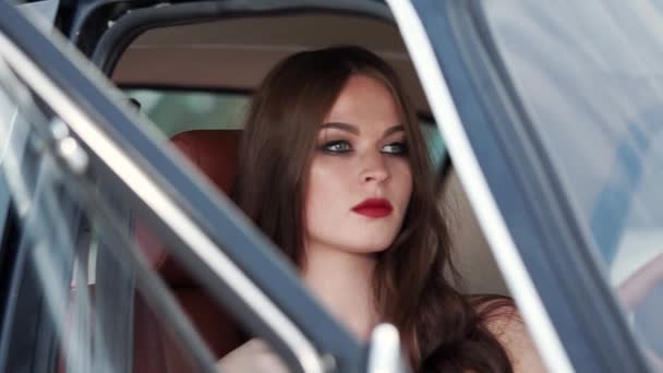 Όμορφη μόδας μοντέλο κάθεται σε ένα κάθισμα του συνοδηγού και οδηγού αναμονής — Αρχείο Βίντεο