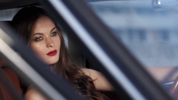 Mooie jonge brunette is rust in een leunstoel van een auto, camera in beweging — Stockvideo