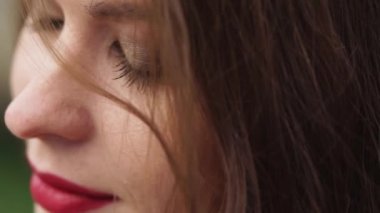 Oldukça genç kahverengi saçlı kadının açık havada rüzgarlı yüz gün, yakın çekim