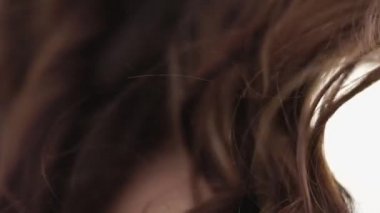 Uzun kahverengi kıvırcık saçları ve rüzgarlı bir gün genç kadının çıplak omuz Close-Up