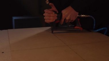 Çalışan bir Sunta panel mobilya konunun tabanı için zımba ile tamir ediyor