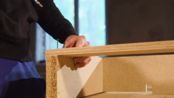 Joiner é mestre está apertando parafusos em detalhes de madeira para montagem — Vídeo de Stock