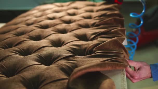 Marangoz kumaş mobilya zımba kullanarak bir kanepe gövdesini tamir ediyor — Stok video