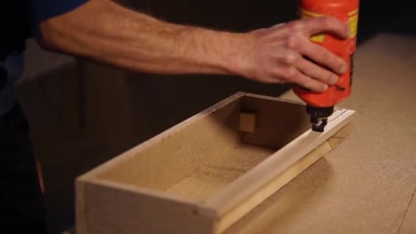 Falegname sta applicando colla liquida su un dettaglio in legno, in piedi in uno studio di lavoro — Video Stock