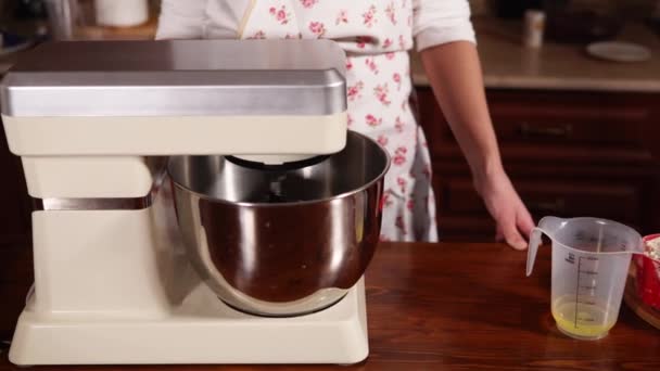 Mélangeur électrique de travail est debout devant la femme sur une table dans la cuisine — Video