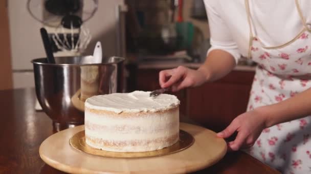 Dolciaria donna è livellamento a lama una parte superiore della torta con panna montata — Video Stock