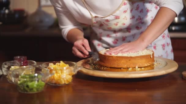 Женщина режет круглую заготовку торта в пекарне — стоковое видео