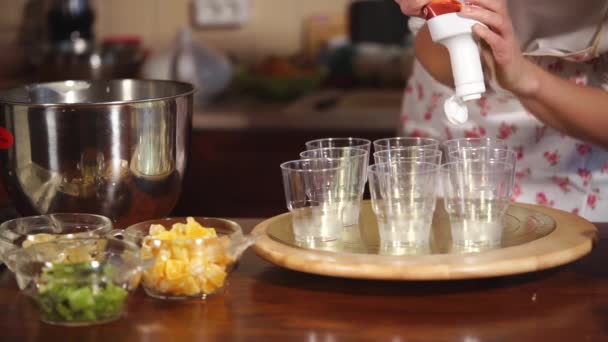 Кондитер сжимает банку с карамелью в бокалы во время приготовления десерта — стоковое видео