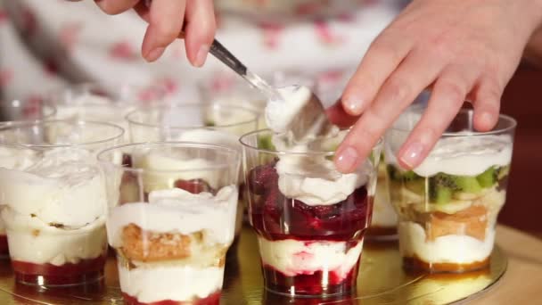 Casalinga sta mettendo panna montata in un bicchiere con marmellata di frutta rossa in cucina — Video Stock