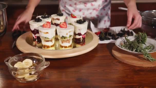 Chef de pastelaria está colocando em topos de taças com sobremesas ervas aromáticas — Vídeo de Stock