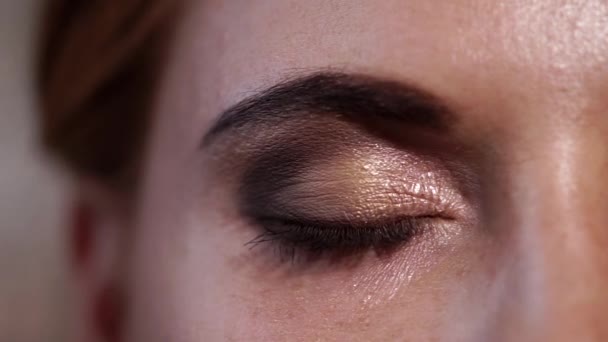 Mujer bonita está abriendo su ojo verde con maquillaje, extremamente cerca — Vídeos de Stock