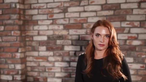 Vrolijke roodharige meisje loopt over grote kamer en flirten met camera — Stockvideo