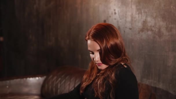 魅惑的な赤毛の女性はカメラ目線と側に頭を回す — ストック動画