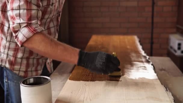 Woodworker está pintando madeira pela cor marrom na oficina de artesanato pequeno — Vídeo de Stock