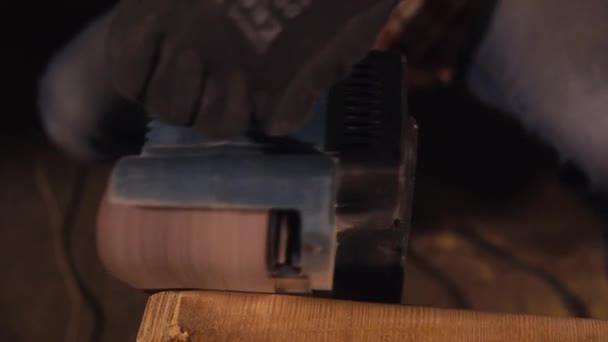 Das Polieren des Elektrowerkzeugs liegt in den Händen des Fabrikarbeiters, der Holz berührt — Stockvideo