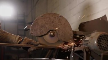 İşçi endüstriyel dönen Perdah tarafından metal kütük bir kenarını keskinleştirme