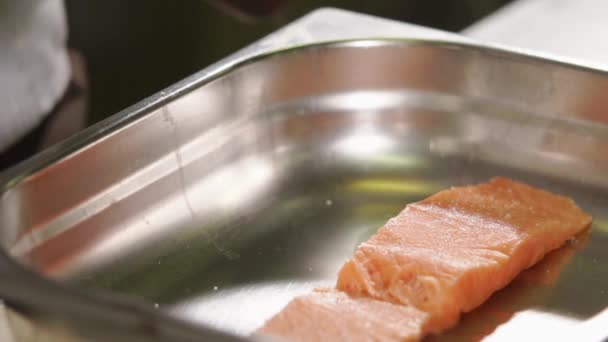 Close up shot of sea trout, the cook sprinkles an appetizing piece of salt fish — Stock Video