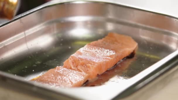 Close up tiro de truta do mar o cozinheiro derrama peixe do mar fresco com molho da lata — Vídeo de Stock