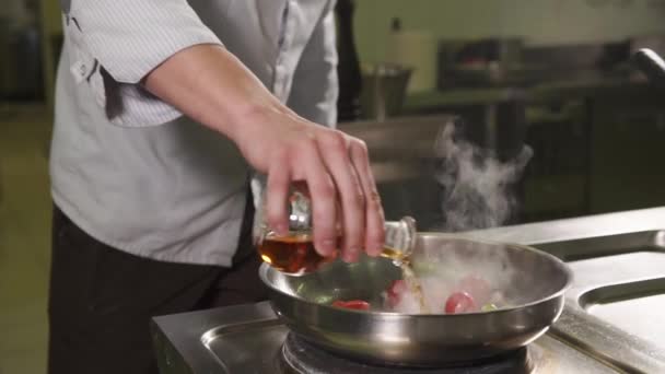 Plan rapproché des mains des chefs, homme arrosage sauce friture sur les légumes à l'huile — Video