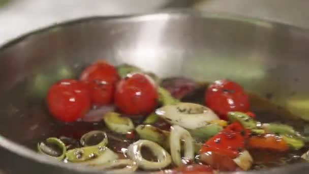 Close up shot of an aluminum frying pan, appetizing vegetables are fried in oil — Stock Video