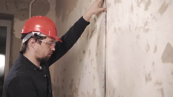 Porträtt av steward, arbetare mäter centimeter längden på väggen — Stockvideo