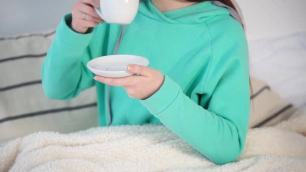 Крупным планом снимок женских рук, которые пьют горячий кофе или чай из чашки — стоковое видео