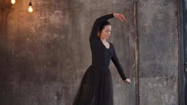 Молодая женщина пытается танцевать балет, исполняет грациозные движения — стоковое видео