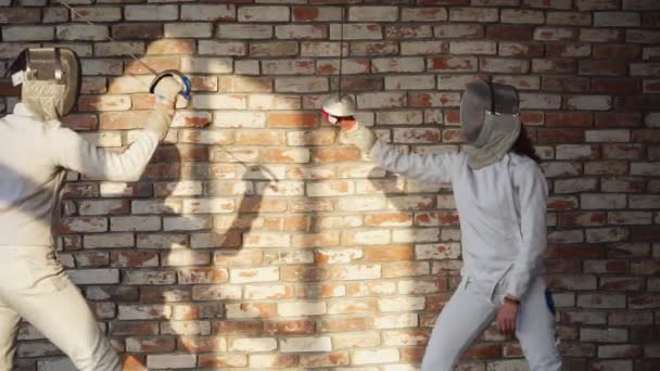 Mann und Frau fechten in Trainingshalle und schlagen mit Degen zu — Stockvideo