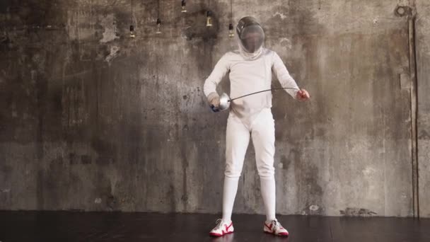 Fencer está verificando e dobrando seu epee e movendo-o no ar em um salão de treinamento — Vídeo de Stock