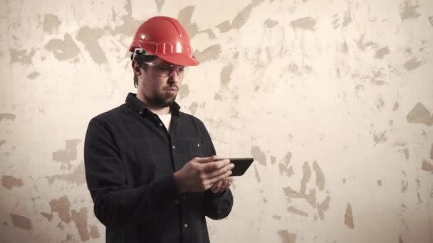 Costruttore professionista in un casco e occhiali in una stanza — Video Stock